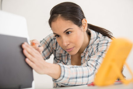 concentrated young woman fixing a desktop computer