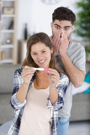 not ready worried man checking pregnancy test with his wife