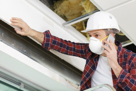 handyman on the phone wearing protective mask
