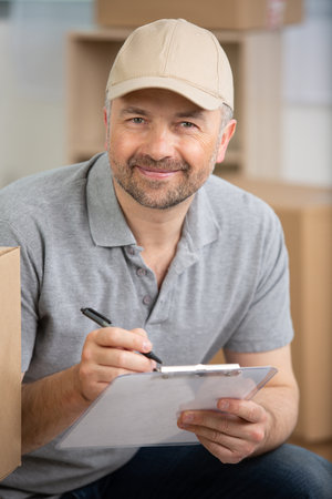 deliveryman with boxes and clipboardの写真素材