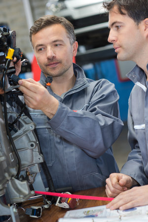 two mechanics fixing cars engine in a garageの写真素材