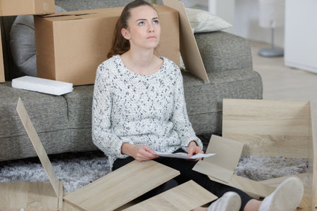 girl with difficulty assembling the furnitureの写真素材