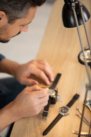 senior watchmaker repairing an old pocket watch