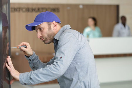 close-up of a male repairman fixing window with screwdriver