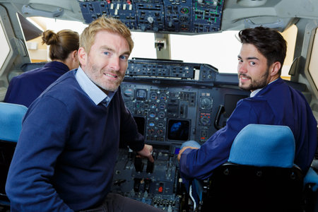 mechanic showing young men inside of cockpit