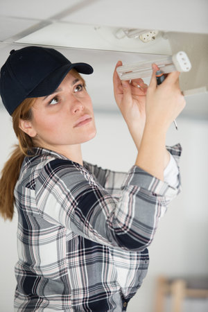 beautiful brunette woman holds low wattage florescent lightの写真素材