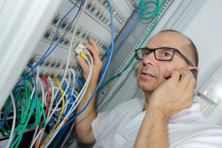 technician talking on mobile phone while analyzing server