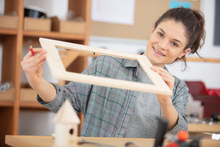 female carpenter choosing quality wooden planks for further work