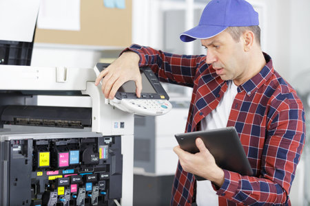 middle aged man fixing a printer