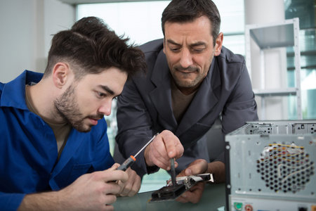 trainee technician learning how to wire up a computer