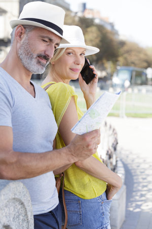 mature couple of tourists finding the right directionの写真素材
