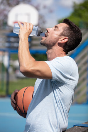 basketball player drinks water outdoorsの写真素材
