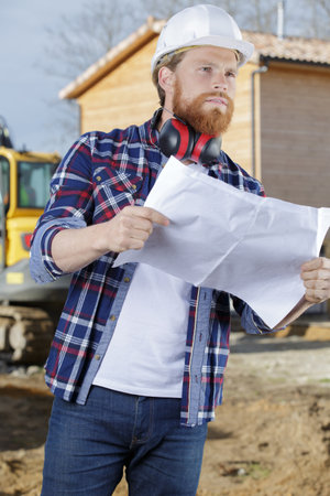 a man builder checking blueprintの写真素材