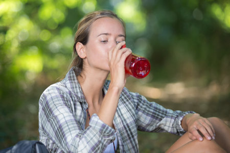 young female walker taking a break for a drinkの写真素材