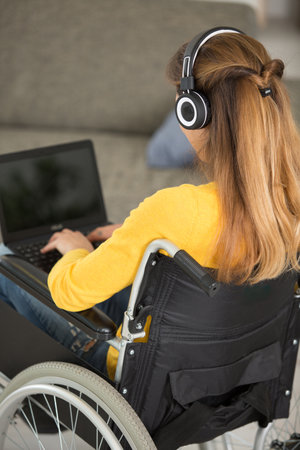 woman on wheelchair checking laptopの写真素材