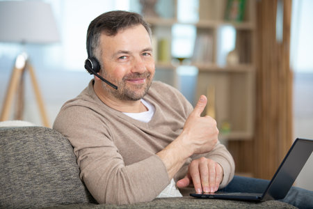 close up man giving a thumbs up and smilingの写真素材