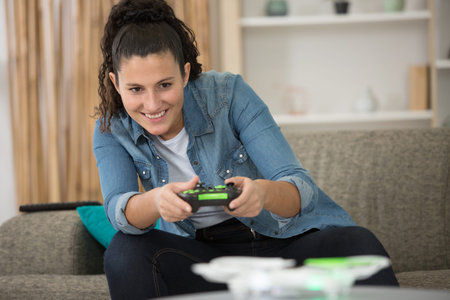 young female gamer playing on her sofa