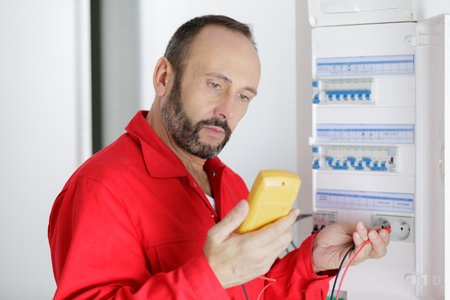 an electrician working with fuse-switch-boardの写真素材