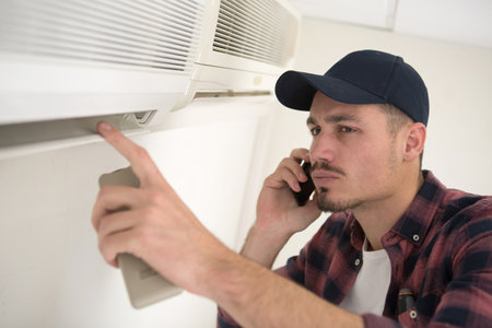 young repairman contractor on the phoneの写真素材
