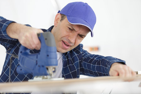 mature man having difficulty using jigsawの写真素材