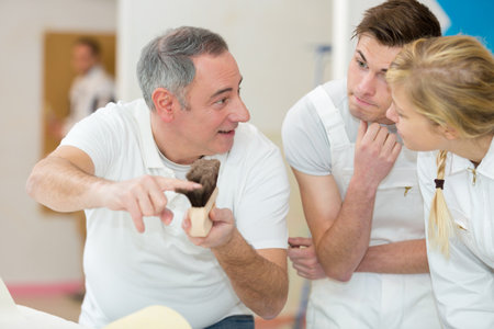 man holding brush with studentsの写真素材