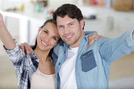 happy man and woman with arms outstretchedの写真素材