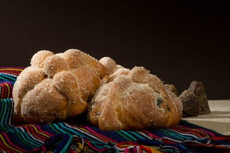 Day of the dead traditional bread with brown sugar on a mexican serape