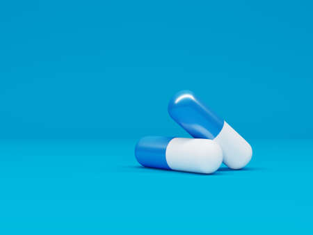 Two capsule pills isolated on blue background. Minimalistic healthcare concept . 3d render. 3d illustration.の写真素材