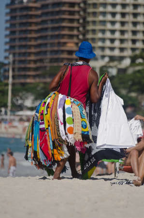 RIO DE JANEIRO, BRAZIL - AUGUST 21, 2012: Brazilian street vendor sells beach wraps on August 21, 2012 at Copacabana Beach, Rio de Janeiro. Brazilのeditorial素材