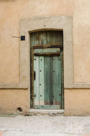 Facade with an ancient door in a street in Val'Quirico, a new town near to Tlaxcala, Mexicoのeditorial素材