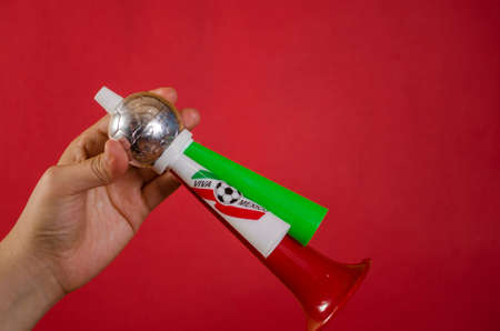 Hand holding a soccer football triple fan trumpetの写真素材