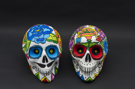 Hand painted  skulls with flowers against black background. Hand painted skulls for Halloween and mexican Day of the dead decorationの写真素材