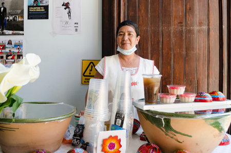 OAXACA, OAXACA, MEXICO- DECEMBER 2, 2018: Smiling woman posing with micoatole, chilacayota water and big clay casseroles with tejate, typical desserts and beverages in Oaxaca, Mexicoのeditorial素材