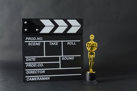 XALAPA, VERACRUZ, MEXICO- FEBRUARY 14, 2019: Plastic Oscar award and clapboard against black backgroundのeditorial素材