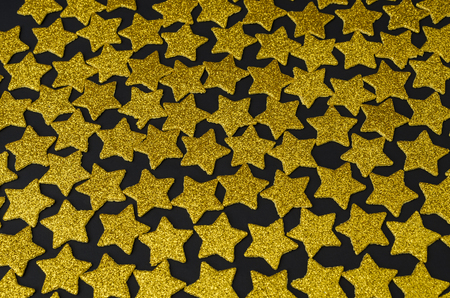 Golden stars against black background. Gold stars glittering on a black backgroundの写真素材