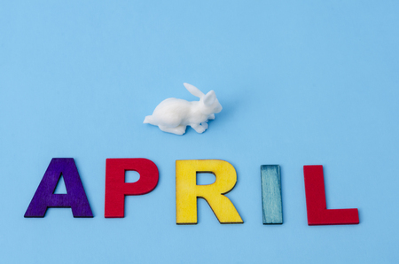 April made from colorful letters and white little bunny on blue background. Easter decorationの写真素材