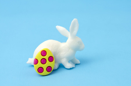 Colorful egg decorated and white bunny on blue background. Decoration for Easter Dayの写真素材