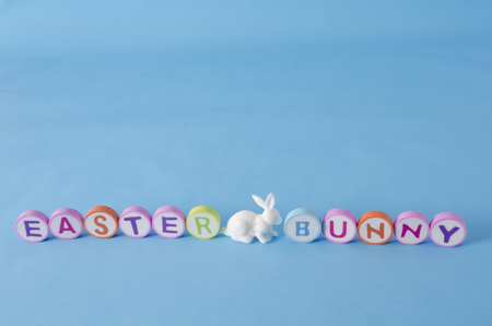 Easter bunny made from colorful letters and white little bunny on blue background. Easter decorationの写真素材