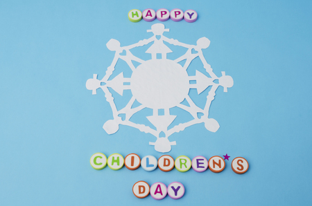 Happy Children's Day made from colorful letters and paper doll chain against blue backgroundの写真素材