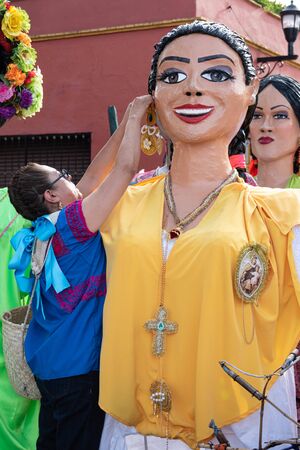 OAXACA, OAXACA, MEXICO- JULY 6, 2019 Woman dressing a giant puppet during the Convite, a party made for invite to a big traditional party called Guelaguetza in Oaxaca, Mexicoのeditorial素材