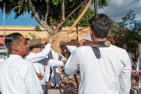 OAXACA, OAXACA, MEXICO- JULY 6 , 2019: Young men dressed with traditional clothes assembling a marmota, a big ball like a ballon, during the Convite, a party made for invite to a big traditional party called Guelaguetza in Oaxaca, Mexicoのeditorial素材