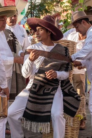 OAXACA, OAXACA, MEXICO- JULY 6, 2019: Young man carrying a basket during the Convite, a party made for invite to a big traditional party called Guelaguetza in Oaxaca, Mexicoのeditorial素材