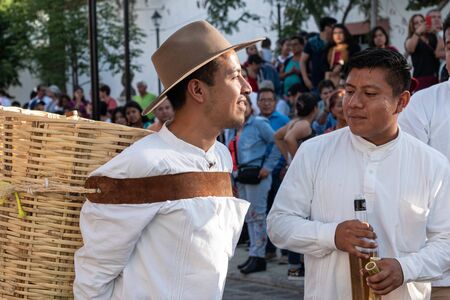 OAXACA, OAXACA, MEXICO- JULY 6, 2019: Young man carrying a basket during the Convite, a party made for invite to a big traditional party called Guelaguetza in Oaxaca, Mexicoのeditorial素材