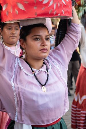 OAXACA, OAXACA, MEXICO- JULY 6, 2019:  Young woman dressed with traditional clothes during the Convite, a party made for invite to a big traditional party called Guelaguetza in Oaxaca, Mexicoのeditorial素材