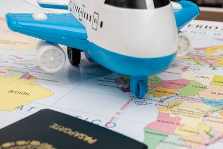 Toy airplane and passport on a map as backgroundの写真素材