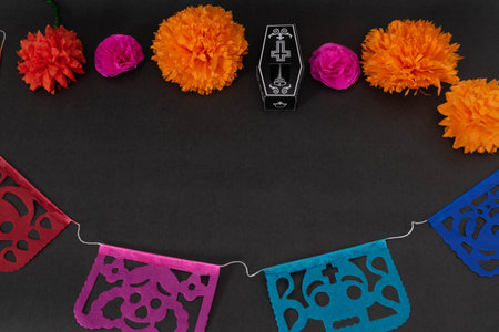 Colorful cut paper, skeleton, coffin, and flowers on black background. Decoration for Day of the...
