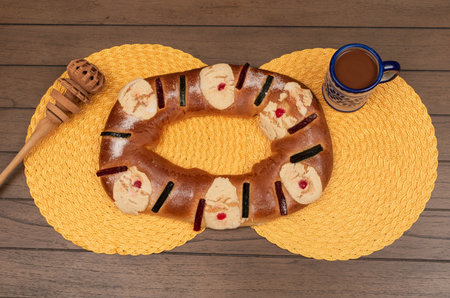 Traditional Epiphany cake, a grinder and a cup of chocolate on a wooden table