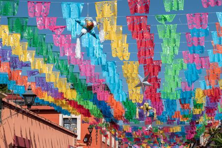 OAXACA, OAXACA, MEXICO- DECEMBER 24, 2019: Jalatlaco neighborhood decorated with colorful cut paper, pinatas and stars for Christmas celebration at a sunny day in Oaxaca, Mexicoのeditorial素材