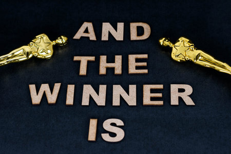 XALAPA, VERACRUZ, MEXICO- JANUARY 31, 2020: Flat lay photography with two plastic Oscar awards and the phrase "And the winner is", made from wooden letters on black backgroundのeditorial素材