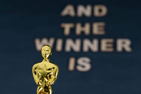 XALAPA, VERACRUZ, MEXICO- JANUARY 31, 2020: Plastic Oscar award and blurred wooden letters with the phrase "And the winner is" on black backgroundのeditorial素材